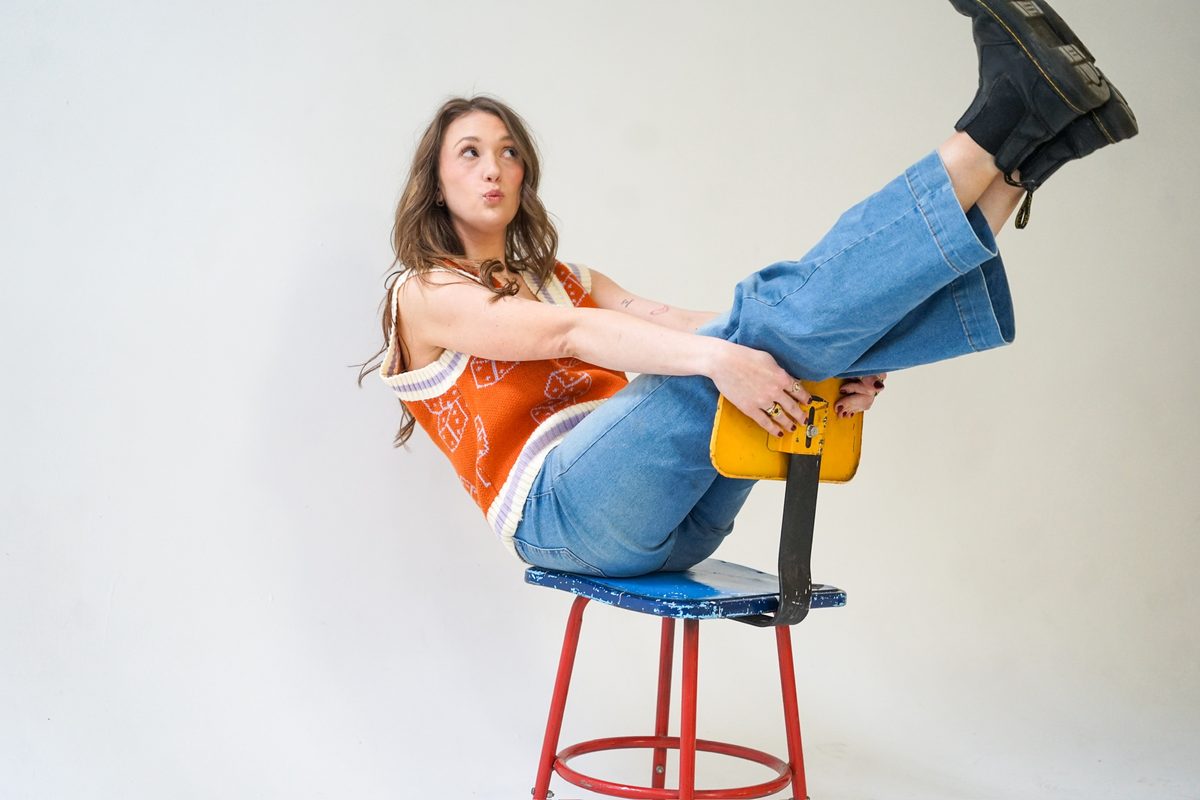 Alise McCreary on a stool with her feet up, laughing